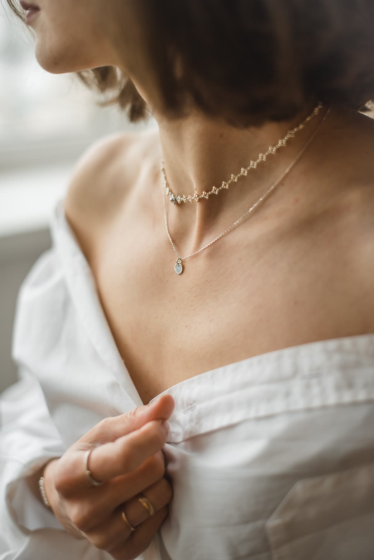 Een fijne gouden ketting op een witte blouse