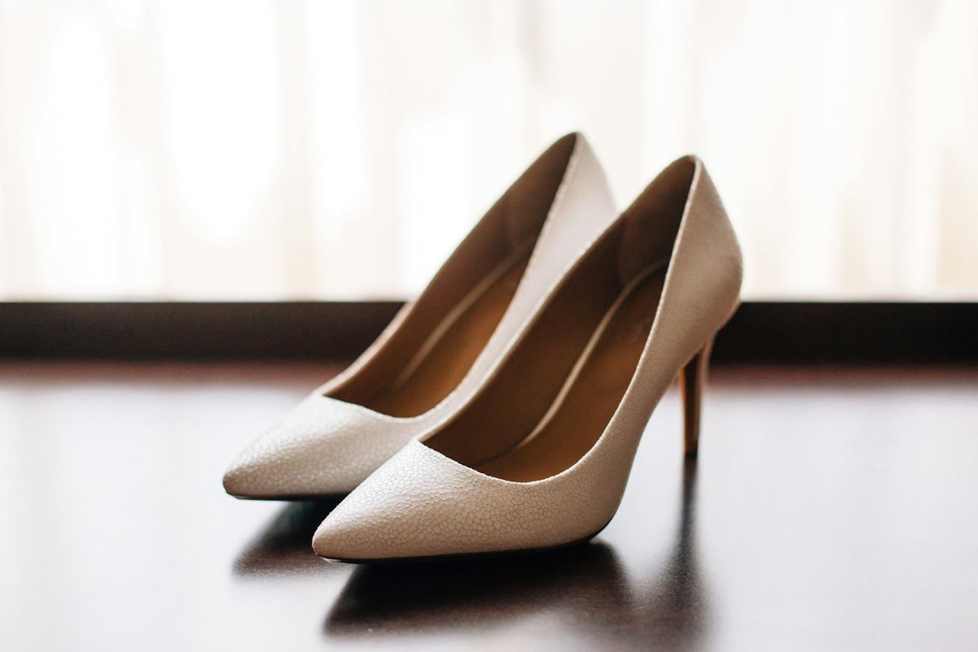 Beige pumps op een donkere tafel