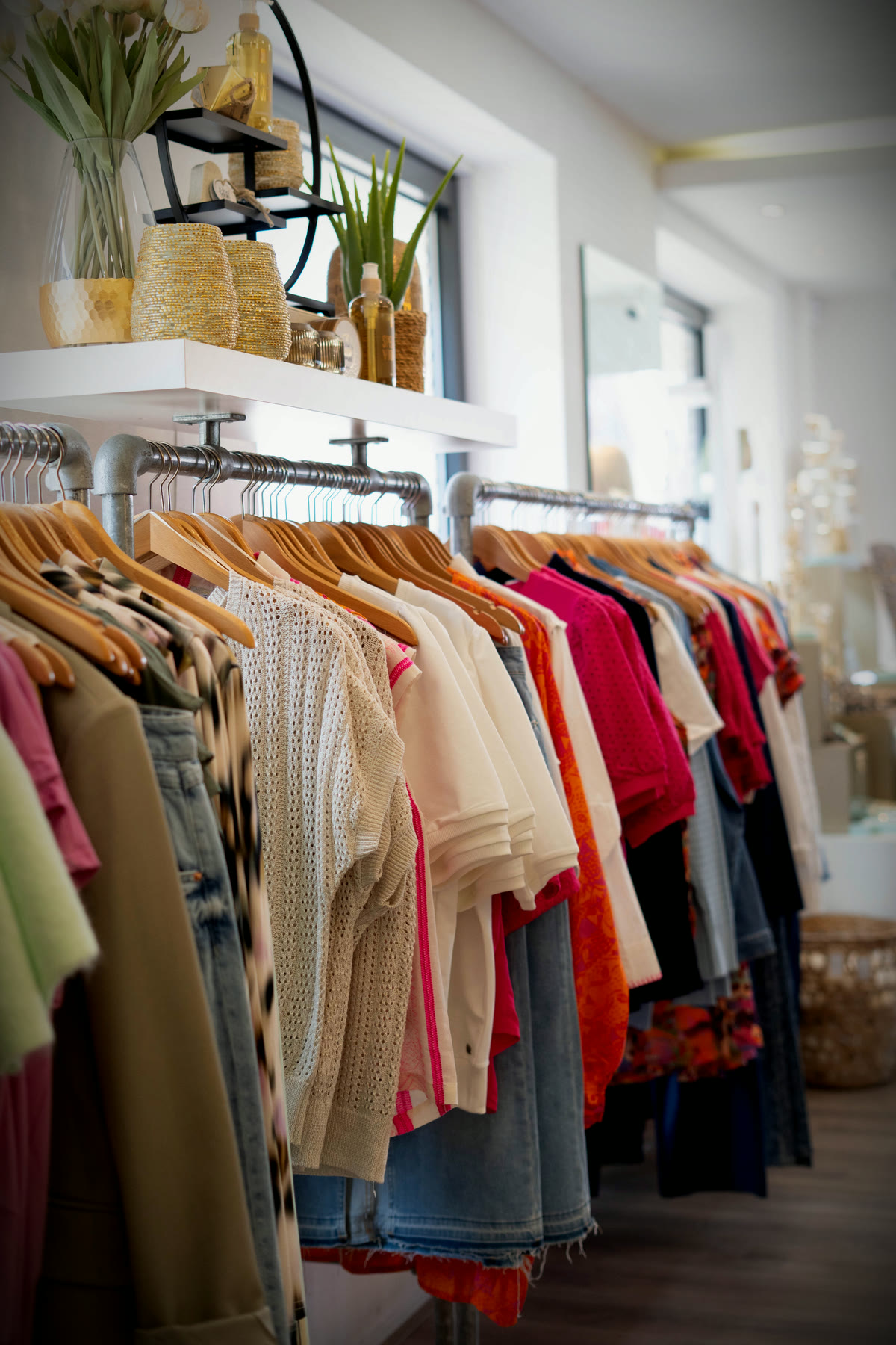 Kledingrekken met blouses, jeans en luchtige zomerstukken